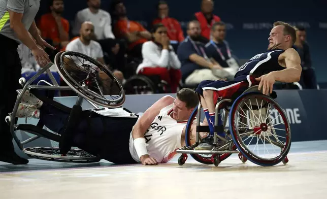 Britain's Lee Manning falls down next to John Boie of the U.S., during the wheelchair basketball men's gold medal match at the 2024 Paralympics, Saturday, Sept. 7, 2024, in Paris, France. (AP Photo/Thomas Padilla)