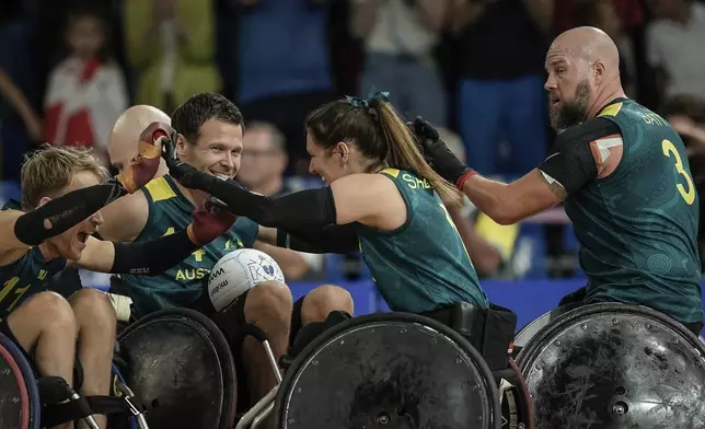 Australia players celebrate after winning the wheelchair rugby bronze medal match between Australia and Great Britain at the 2024 Paralympics, Monday, Sept. 2, 2024, in Paris, France. (AP Photo/Aurelien Morissard)