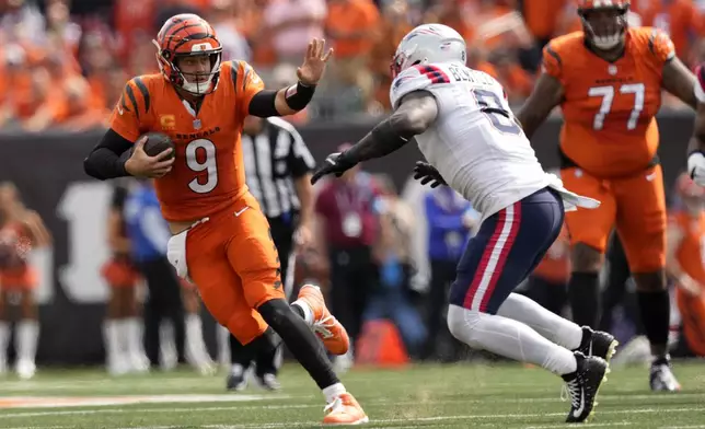 Cincinnati Bengals quarterback Joe Burrow (9) runs from New England Patriots linebacker Ja'Whaun Bentley (8) during the second half of an NFL football game, Sunday, Sept. 8, 2024, in Cincinnati. (AP Photo/Carolyn Kaster)