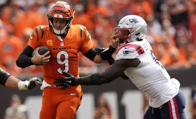 Cincinnati Bengals quarterback Joe Burrow (9) runs from New England Patriots linebacker Ja'Whaun Bentley (8) during the second half of an NFL football game, Sunday, Sept. 8, 2024, in Cincinnati. (AP Photo/Carolyn Kaster)