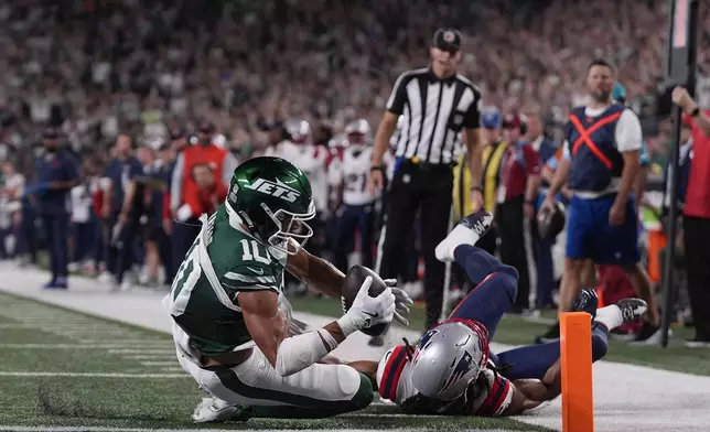 New York Jets wide receiver Allen Lazard (10) scores a touchdown against New England Patriots safety Kyle Dugger (23) during the first quarter of an NFL football game, Thursday, Sept. 19, 2024, in East Rutherford, N.J. (AP Photo/Julia Demaree Nikhinson)