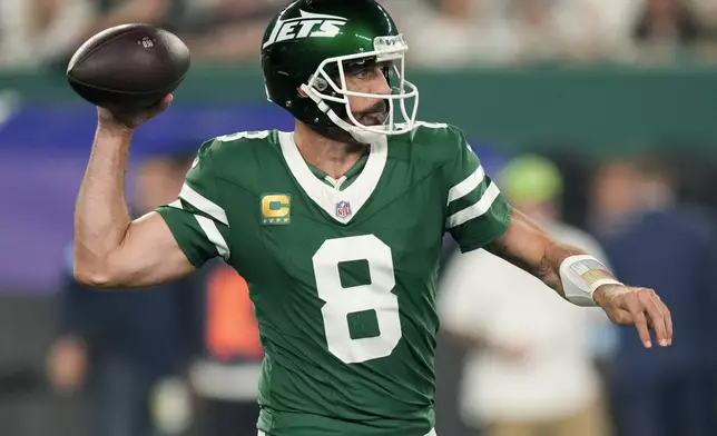 New York Jets quarterback Aaron Rodgers (8) passes against the New England Patriots during the first quarter of an NFL football game, Thursday, Sept. 19, 2024, in East Rutherford, N.J. (AP Photo/Seth Wenig)