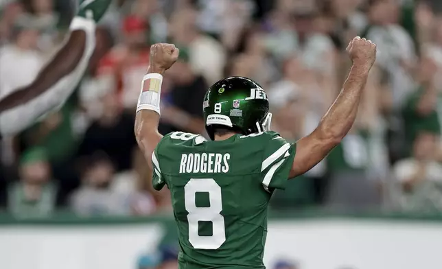 New York Jets quarterback Aaron Rodgers (8) reacts after throwing a touchdown pass against the New England Patriots during the first quarter of an NFL football game, Thursday, Sept. 19, 2024, in East Rutherford, N.J. (AP Photo/Adam Hunger)