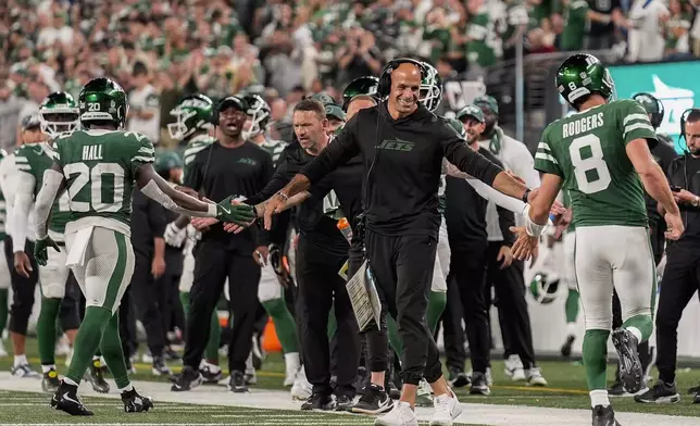 New York Jets head coach Robert Saleh congratulates New York Jets running back Breece Hall (20) and quarterback Aaron Rodgers (8) after the Jets scored a touchdown against the New England Patriots during the third quarter of an NFL football game, Thursday, Sept. 19, 2024, in East Rutherford, N.J. (AP Photo/Seth Wenig)