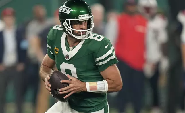 New York Jets quarterback Aaron Rodgers (8) steps back to pass against the New England Patriots during the first quarter of an NFL football game, Thursday, Sept. 19, 2024, in East Rutherford, N.J. (AP Photo/Seth Wenig)