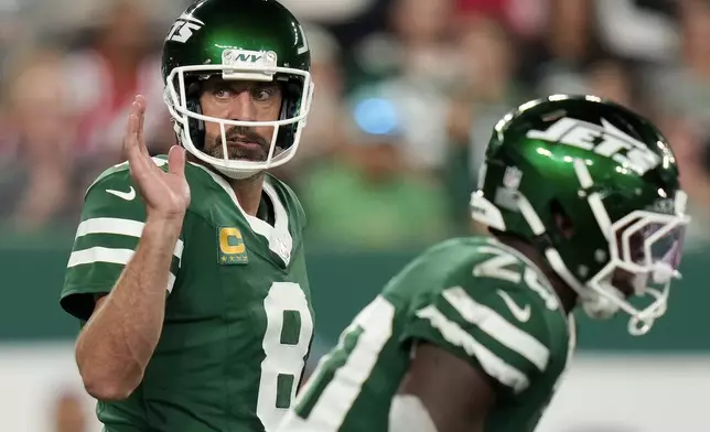 New York Jets quarterback Aaron Rodgers (8) motions on the line of scrimmage against the New England Patriots during the first quarter of an NFL football game, Thursday, Sept. 19, 2024, in East Rutherford, N.J. (AP Photo/Seth Wenig)