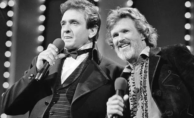 FILE - Country stars Johnny Cash, left and Kris Kristofferson sing during the Country Music Awards in Nashville, Tenn., Oct. 1983. Kristofferson, a Rhodes scholar with a deft writing style and rough charisma who became a country music superstar and A-list Hollywood actor, has died Saturday, Sept. 28, 2024. (AP Photo, File)