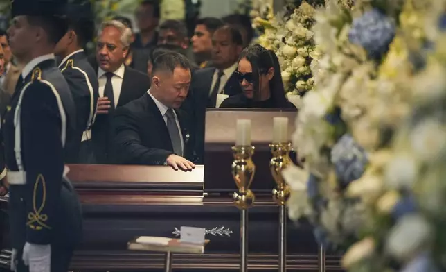 Kenji Fujimori stands by the coffin of his father, former President Alberto Fujimori, during his wake in Lima, Peru, Thursday, Sept. 12, 2024. (AP Photo/Guadalupe Pardo)