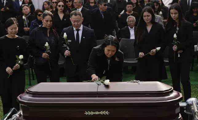 Keiko Fujimori places a flower over the coffin of her father, former President Alberto Fujimori, in Lima, Peru, Saturday, Sept. 14, 2024. (AP Photo/Guadalupe Pardo)