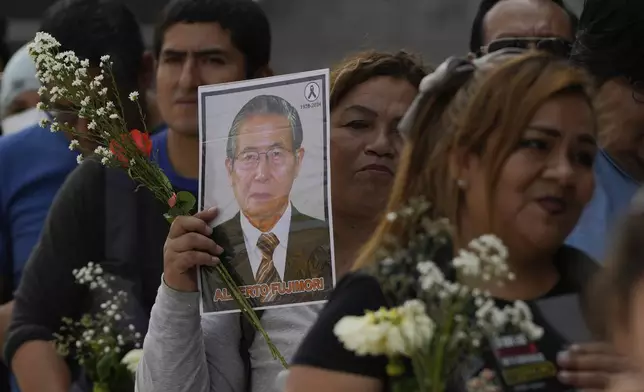 Supporters of former President Alberto Fujimori line up to pay their respects outside a museum where his body is lying in Lima, Peru, Thursday, Sept. 12, 2024. (AP Photo/Guadalupe Pardo)