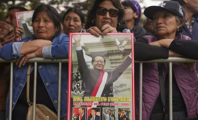 Supporters of former President Alberto Fujimori gather outside the cemetery during his funeral in Lima, Peru, Saturday, Sept. 14, 2024. (AP Photo/Guadalupe Pardo)