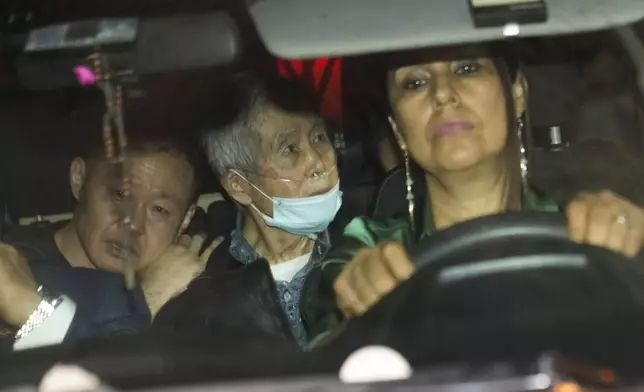 FILE - Peru's former President Alberto Fujimori, center, is driven out of prison by one of his lawyers, accompanied by his son Kenji, left, after his release, in Callao, Peru, Dec. 6, 2023. His daughter Keiko Fujimori announced in a post on X that he died of cancer on Wednesday, September 11, 2024. (AP Photo/Martin Mejia, File)