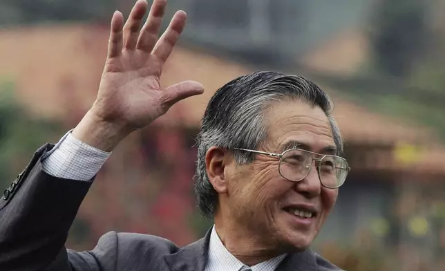 FILE - Former Peru's President Alberto Fujimori waves at his home in Santiago after leaving the academy for the training of corrections officers in Santiago, Chile, May 18, 2006. (AP Photo/Claudio Santana, File)