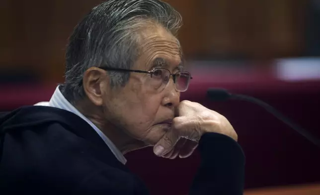 FILE - Peru's jailed, former President Alberto Fujimori, photographed through a glass window, attends his trial at a police base on the outskirts of Lima, Peru, June 28, 2016. His daughter Keiko Fujimori announced in a post on X that he died of cancer on Wednesday, September 11, 2024. (AP Photo/Martin Mejia, File)