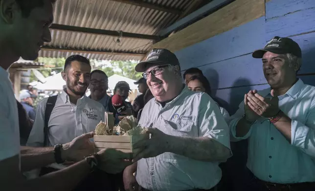 FILE - Howard Buffett receives presents during a visit with Colombia's President Ivan Duque, right, at a cocoa farm on Jan. 29, 2020 in La Gabarra, Colombia. (AP Photo/Ivan Valencia, File)