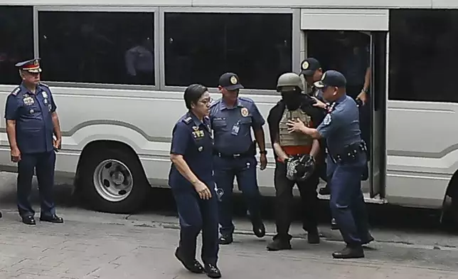 Apollo Carreon Quiboloy, wearing a helmet and flak jacket, a Filipino preacher charged with human trafficking, arrives at the Pasig Regional Trial Court in Pasig City, Philippines, Friday, Sept. 13, 2024. (AP Photo/Gerard Carreon)