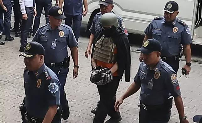 Apollo Carreon Quiboloy, wearing a helmet and flak jacket, a Filipino preacher charged with human trafficking, enters the Pasig Regional Trial Court in Pasig City, Philippines, Friday, Sept. 13, 2024. (AP Photo/Gerard Carreon)