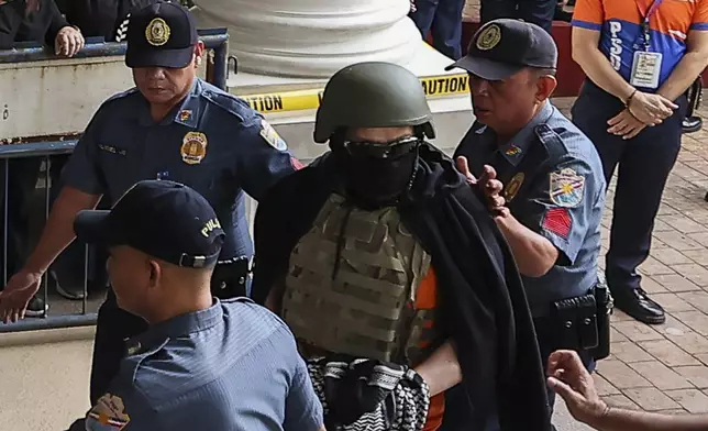 Apollo Carreon Quiboloy, wearing a helmet and flak jacket, a Filipino preacher charged with human trafficking, enters the Pasig Regional Trial Court in Pasig City, Philippines, Friday, Sept. 13, 2024. (AP Photo/Gerard Carreon)