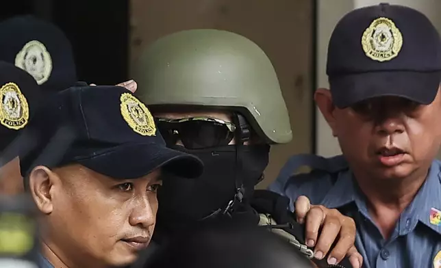 Apollo Carreon Quiboloy, wearing a helmet and flak jacket, a Filipino preacher charged with human trafficking, leaves the Pasig Regional Trial Court in Pasig City, Philippines, Friday, Sept. 13, 2024. (AP Photo/Gerard Carreon)