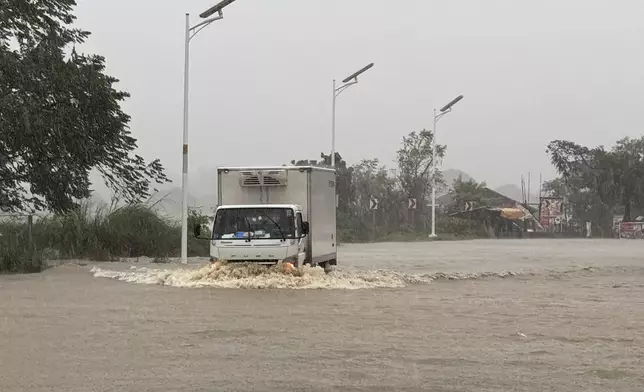 A truck negotiates flood waters caused by powerful Typhoon Krathon locally called "Typhoon Julian" at Bacarra, Ilocos Norte province, northern Philippines on Monday, Sept. 30, 2024. (AP Photo/Bernie Dela Cruz)