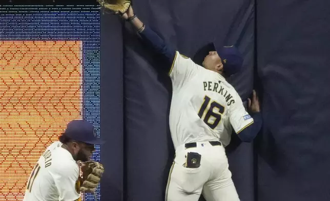 Milwaukee Brewers' Blake Perkins and Jackson Chourio can't catch a home run hit by Philadelphia Phillies' Brandon Marsh during the fifth inning of a baseball game Monday, Sept. 16, 2024, in Milwaukee. (AP Photo/Morry Gash)