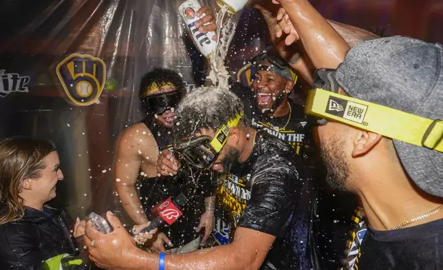 Milwaukee Brewers' Jackson Chourio is douced after a baseball game against the Philadelphia Phillies Wednesday, Sept. 18, 2024, in Milwaukee. The Brewers won 2-1 and clinched the National League Central division. (AP Photo/Morry Gash)