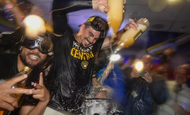 Milwaukee Brewers' Willy Adames douces Enoli Paredes after a baseball game against the Philadelphia Phillies Wednesday, Sept. 18, 2024, in Milwaukee. The Brewers won 2-1 and clinched the National League Central division. (AP Photo/Morry Gash)