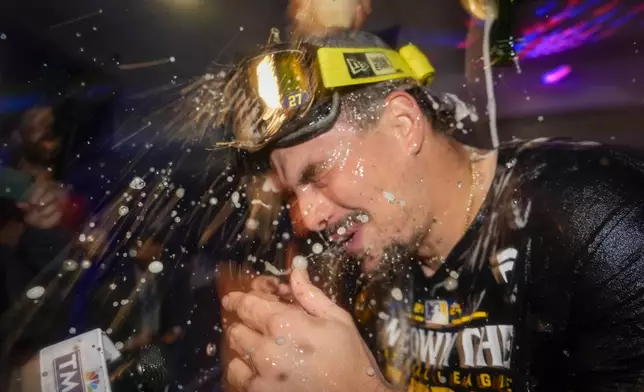 Milwaukee Brewers' Willy Adames is douced after a baseball game against the Philadelphia Phillies Wednesday, Sept. 18, 2024, in Milwaukee. The Brewers won 2-1 and clinched the National League Central division. (AP Photo/Morry Gash)