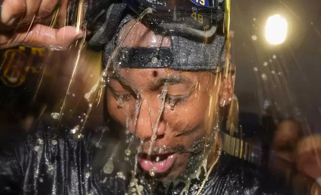 Milwaukee Brewers' Enoli Paredes is douced after a baseball game against the Philadelphia Phillies Wednesday, Sept. 18, 2024, in Milwaukee. The Brewers won 2-1 and clinched the National League Central division. (AP Photo/Morry Gash)