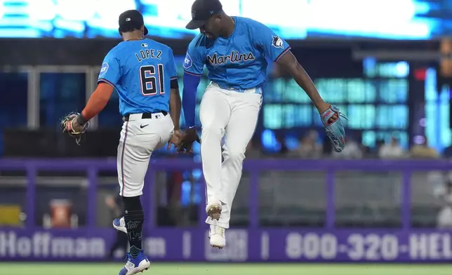 Miami Marlins second baseman Otto Lopez (61) and right fielder Jesus Sanchez, right, celebrate after defeating the Philadelphia Phillies in a baseball game, Sunday, Sept. 8, 2024, in Miami. (AP Photo/Lynne Sladky)