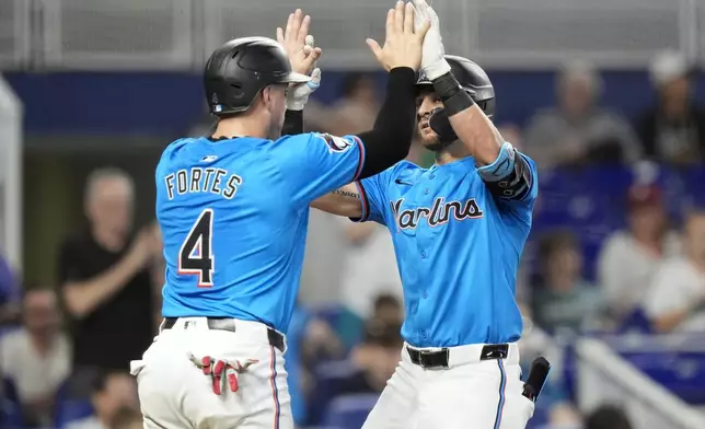 Miami Marlins' Connor Norby, right, is met by Nick Fortes (4) at the plate after hitting a two-run home run during the third inning of a baseball game against the Philadelphia Phillies, Sunday, Sept. 8, 2024, in Miami. (AP Photo/Lynne Sladky)