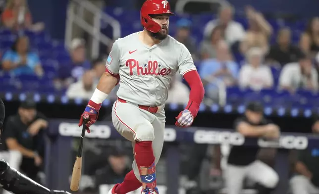 Philadelphia Phillies' Kyle Schwarber prepares to run to first on a throwing error by Miami Marlins first baseman Jake Burger during the first inning of a baseball game, Friday, Sept. 6, 2024, in Miami. (AP Photo/Lynne Sladky)