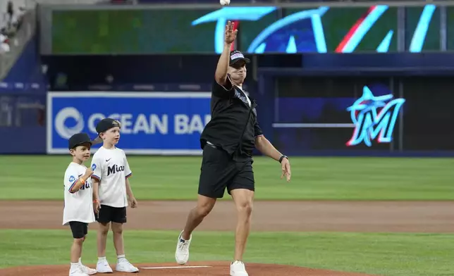 Florida Panthers player Evan Rodrigues, right, throws a ceremonial pitch before a baseball game between the Miami Marlins and the Philadelphia Phillies, Friday, Sept. 6, 2024, in Miami. (AP Photo/Lynne Sladky)