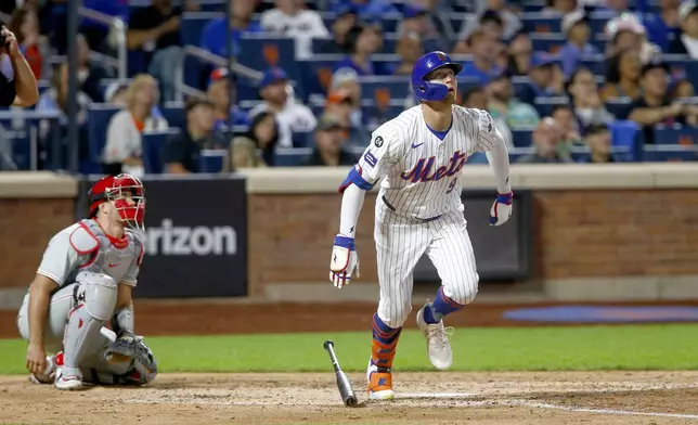 New York Mets' Brandon Nimmo, right, watches his solo home run in the sixth inning during a baseball game against the Philadelphia Phillies, Sunday, Sept. 22, 2024, in New York. (AP Photo/John Munson)