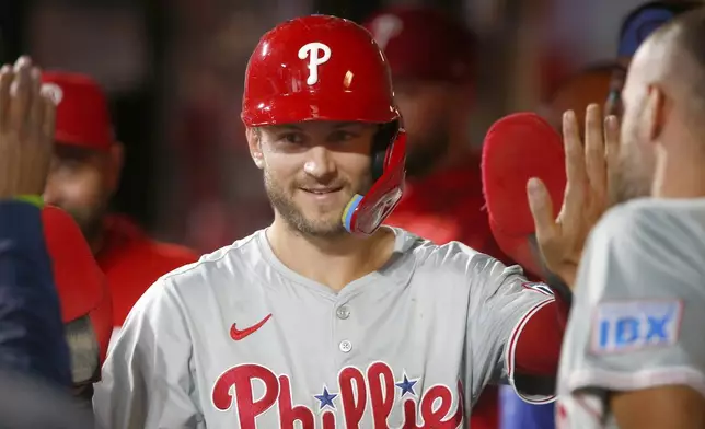 Philadelphia Phillies' Trea Turner returns to the dugout after scoring in the first inning during a baseball game against the New York Mets, Sunday, Sept. 22, 2024, in New York. (AP Photo/John Munson)