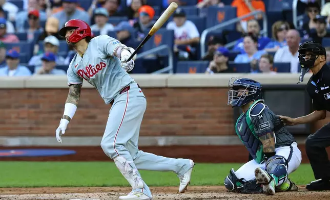 Philadelphia Phillies' Nick Castellanos follows through on a home run during the fifth inning of a baseball game against the New York Mets, Saturday, Sept. 21, 2024, in New York. (AP Photo/Noah K. Murray)