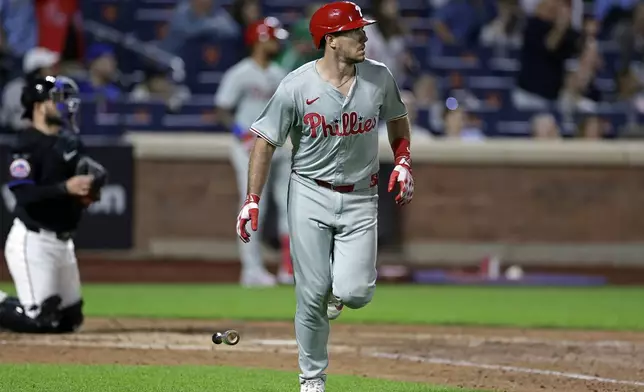 Philadelphia Phillies' J.T. Realmuto, right, watches his two-run home run during the eighth inning of a baseball game against the New York Mets, Friday, Sept. 20, 2024, in New York. (AP Photo/Adam Hunger)