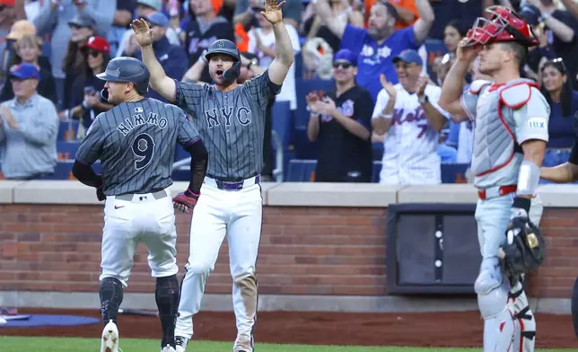 New York Mets' Pete Alonso, second from left, and Brandon Nimmo (9) react after scoring on a double by Francisco Alvarez during the seventh inning of a baseball game, Saturday, Sept. 21, 2024, in New York. (AP Photo/Noah K. Murray)