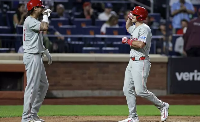 Philadelphia Phillies' J.T. Realmuto, right, is congratulated by Nick Castellanos, left, after hitting a two-run home run during the eighth inning of a baseball game against the New York Mets, Friday, Sept. 20, 2024, in New York. (AP Photo/Adam Hunger)