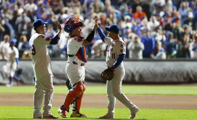 New York Mets relief pitcher Edwin Diaz, left, catcher Francisco Alvarez, center, and second baseman Jose Iglesias celebrate after a baseball game against the Philadelphia Phillies Sunday, Sept. 22, 2024, in New York. (AP Photo/John Munson)