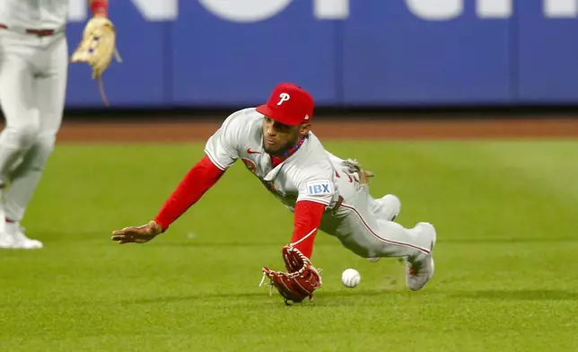 Philadelphia Phillies center fielder Johan Rojas dives but cannot catch a single by New York Mets' Tyrone Taylor in the fifth inning during a baseball game Sunday, Sept. 22, 2024, in New York. (AP Photo/John Munson)