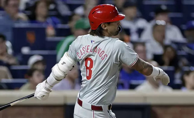 Philadelphia Phillies' Nick Castellanos hits an RBI double during the third inning of a baseball game against the New York Mets, Friday, Sept. 20, 2024, in New York. (AP Photo/Adam Hunger)