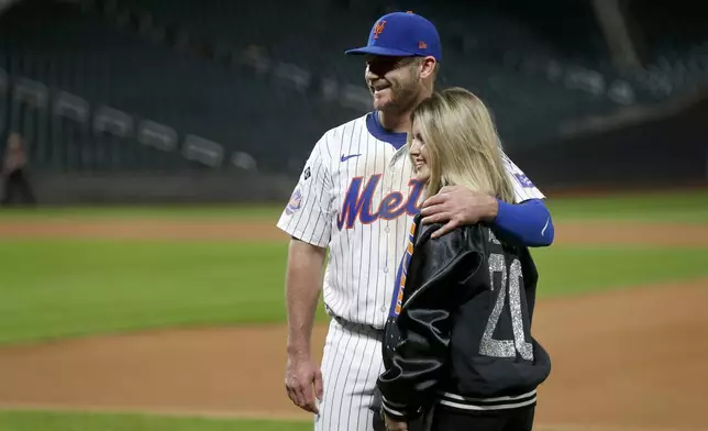 New York Mets first baseman Pete Alonso came back out onto the field to take pictures with his wife Haley after a baseball game against the Philadelphia Phillies, Sunday, Sept. 22, 2024, in New York. (AP Photo/John Munson)