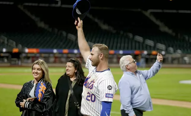 New York Mets first baseman Pete Alonso came back out onto the field to take pictures with his family after a baseball game against the Philadelphia Phillies Sunday, Sept. 22, 2024, in New York. (AP Photo/John Munson)