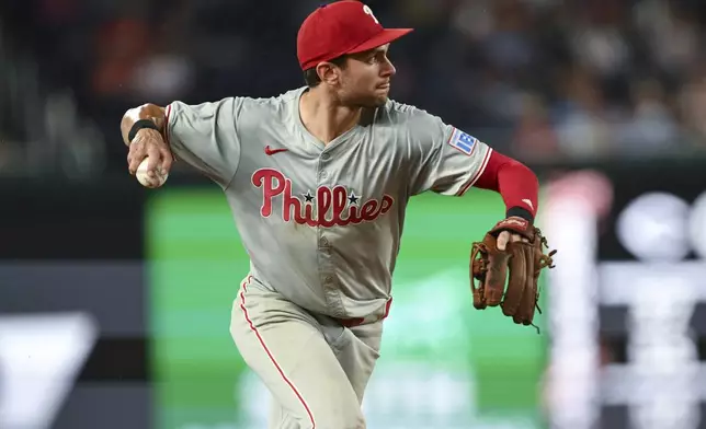 Philadelphia Phillies shortstop Trea Turner throws to first base for an out on a ball hit by Washington Nationals' Jacob Young during the third inning of a baseball game, Friday, Sept. 27, 2024, in Washington. (AP Photo/Terrance Williams)