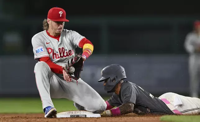 Washington Nationals' Nasim Nuñez steals second base and avoids the tag from Philadelphia Phillies second baseman Bryson Stott during the third inning of a baseball game, Friday, Sept. 27, 2024, in Washington. (AP Photo/Terrance Williams)