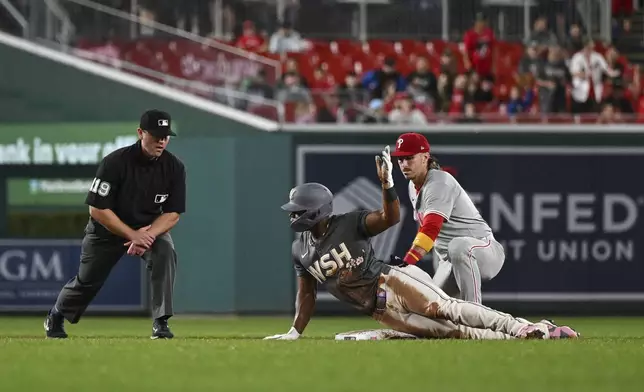 Washington Nationals' Stone Garrett gestures after hitting a double and sliding into second base while avoiding the tag from Philadelphia Phillies second baseman Bryson Stott during the seventh inning of a baseball game, Friday, Sept. 27, 2024, in Washington. (AP Photo/Terrance Williams)