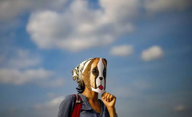 A woman wears a mask during a protest against a bill approved by Turkish legislators that aims to remove stray dogs off the country's streets, in Istanbul, Turkey, Sunday, Sept. 1, 2024. (AP Photo/Emrah Gurel)