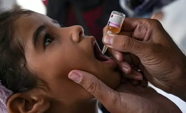 A health worker administers a polio vaccine to a child at a hospital in Deir al-Balah, central Gaza Strip, Sunday, Sept. 1, 2024. (AP Photo/Abdel Kareem Hana)