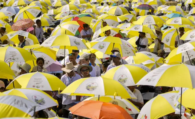 Faithful use umbrellas with the colors of the Vatican flag to shield themselves from the sun as they wait for a mass presided over by Pope Francis to start in Tasitolu, some 8 kilometers west of Dili, East Timor, Tuesday, Sept. 10, 2024. (AP Photo/Gregorio Borgia)